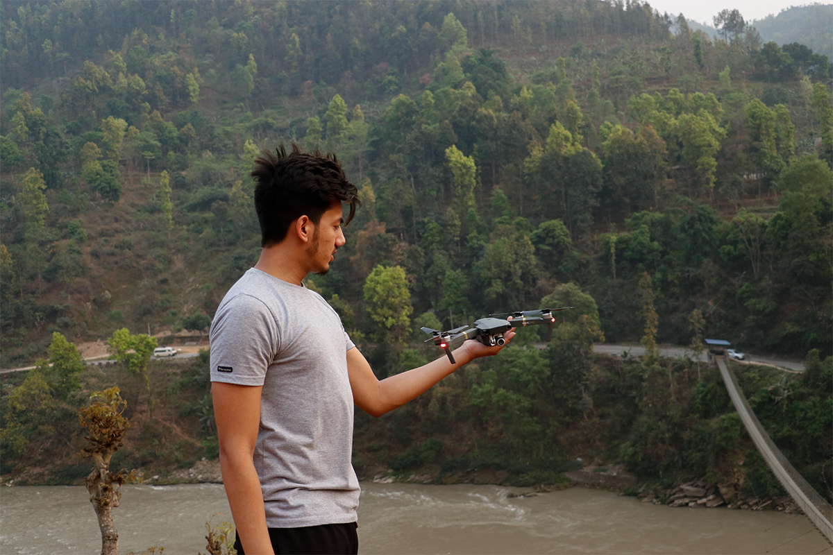 a person trying fly drone in trishuli riverside