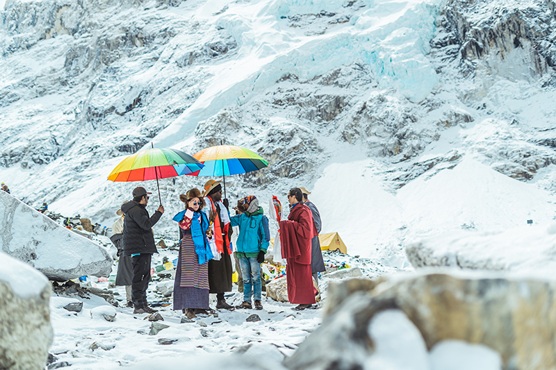 people standing with umbrellas in the mountains snow everywhere around
