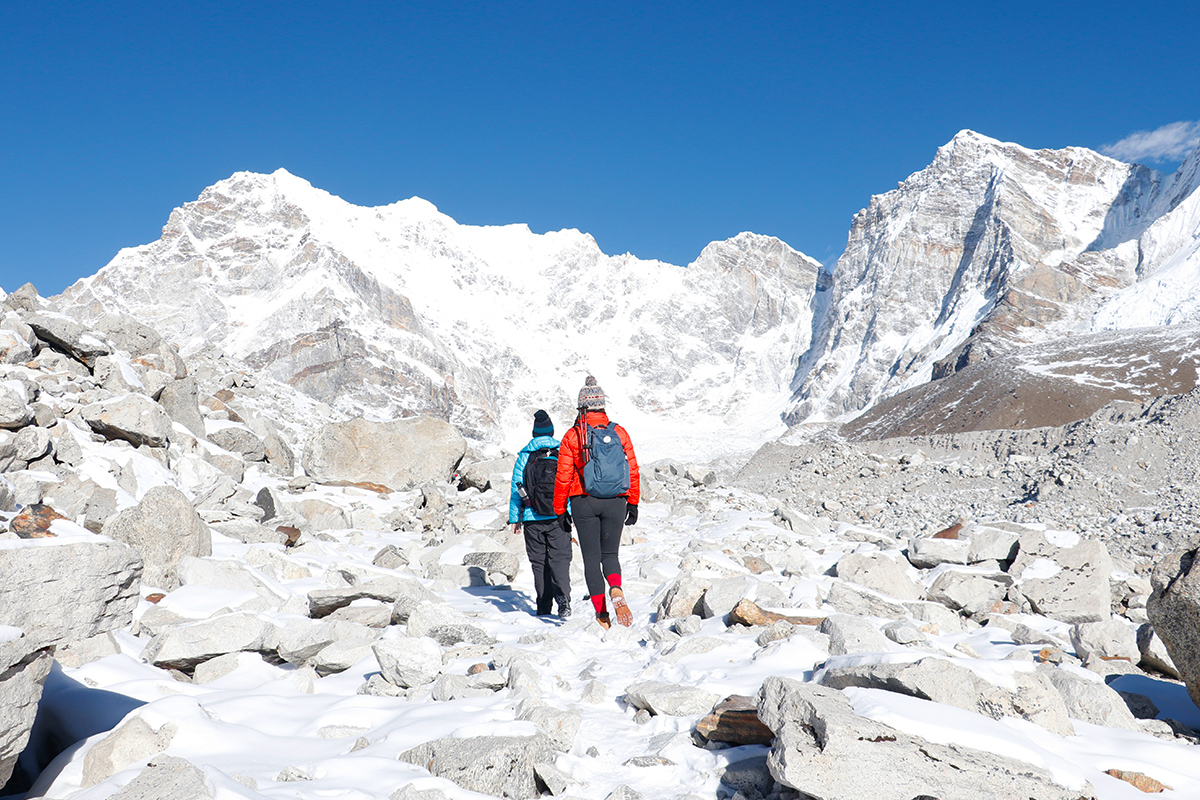 Two trekkers walking on snowy way