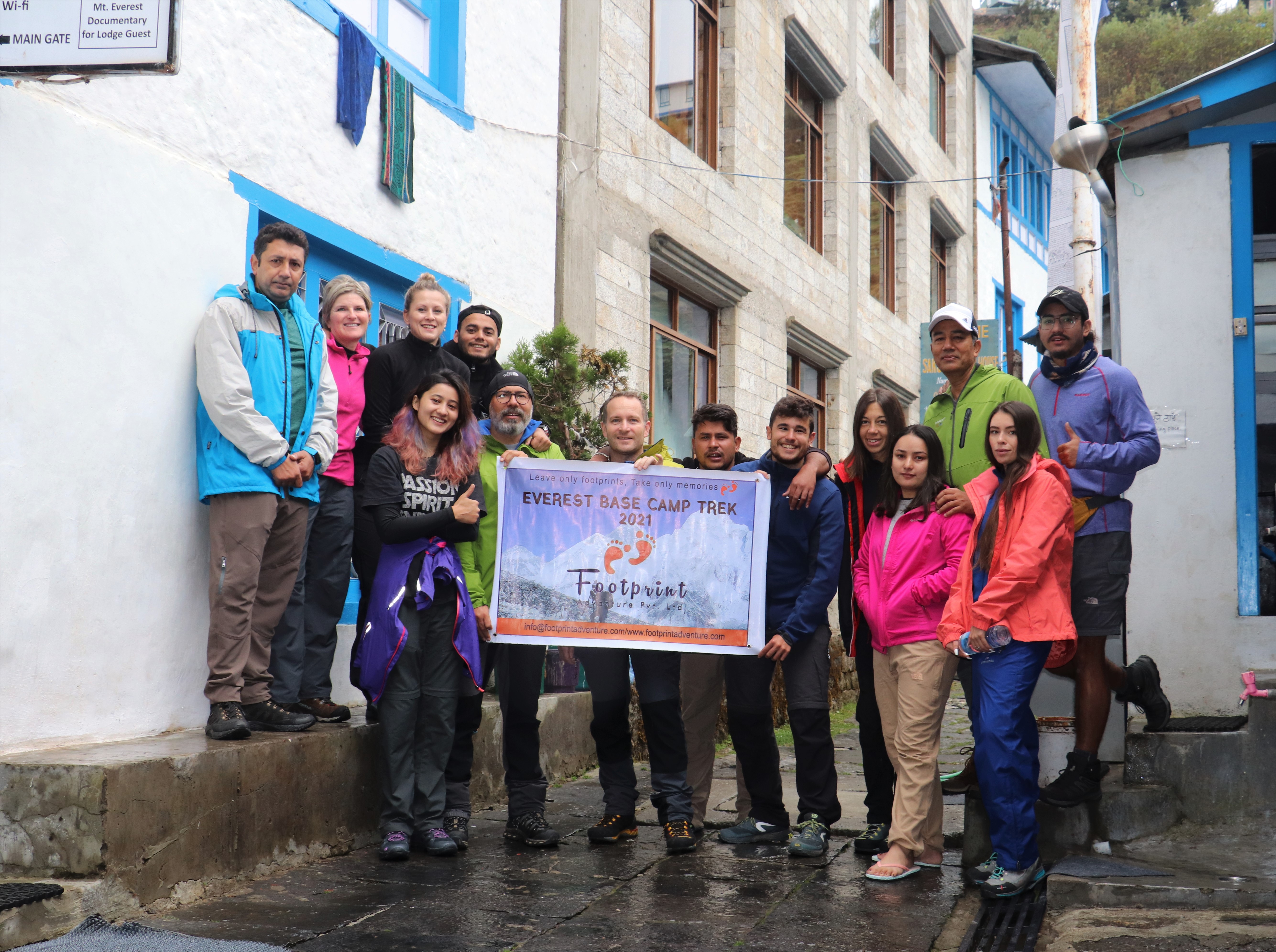 Group of smiling faces holding the banner of "Footprint Adventure" at Namche Bazar on Everest Base Camp Trek
