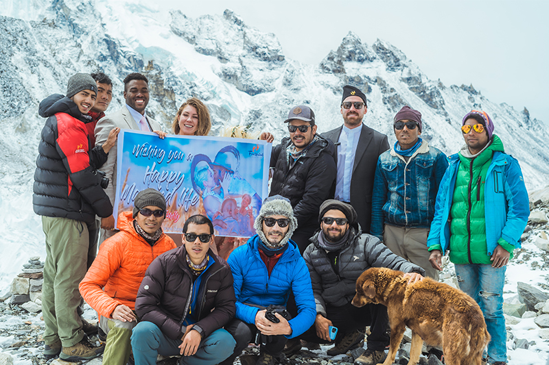 group of people holding banner and a dog somewhere in the mountains