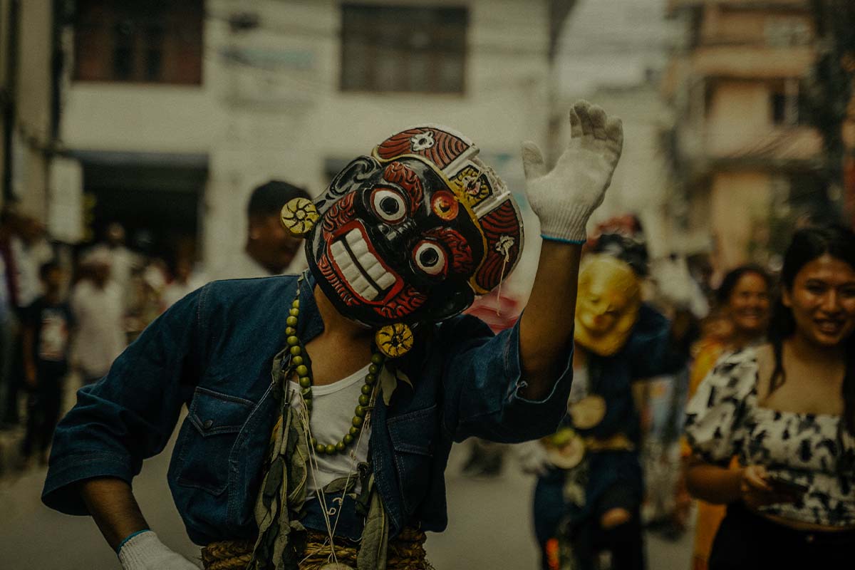 ​​Person with a mask dancing during Gai Jatra Festival in Nepal