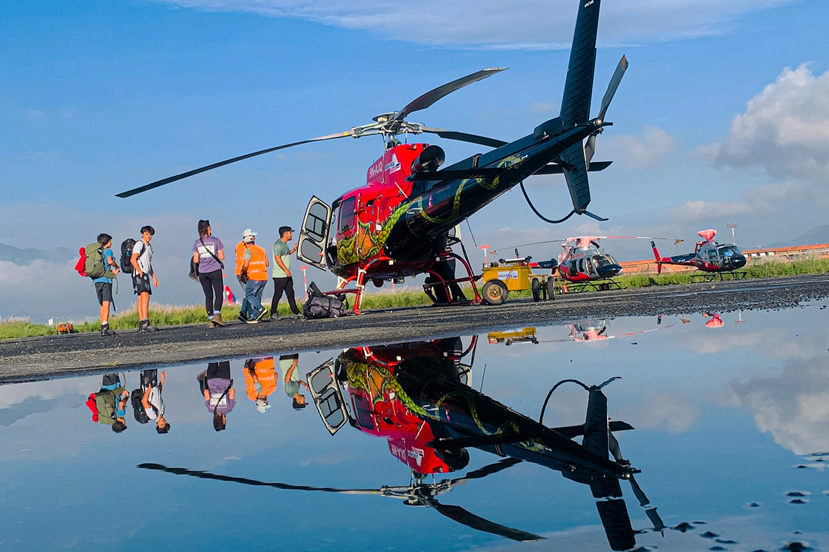 reflection of people about to enter a helicopter in queue seen in water